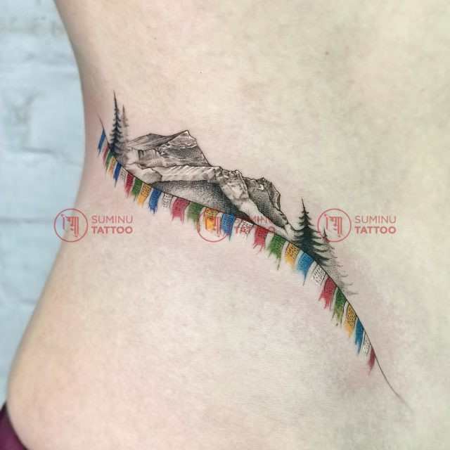 mountain-travel-tattoo-with-prayer-flags-on-side-waist-of-a-women-tattoo